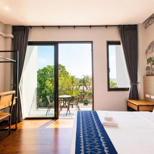 a bedroom with a bed and a balcony at The Riva Vientiane Hotel in Vientiane