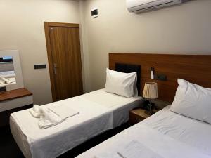 a hotel room with two beds and a mirror at Hotel Bergama in Istanbul +4 photos