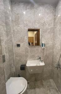 a bathroom with a sink and a toilet and a mirror at Hotel Bergama in Istanbul