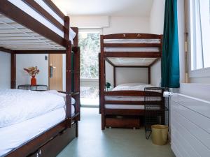 a bedroom with two bunk beds and a window at Hôtel historique Chez Elsy - Crans-Sapins in Crans-Montana