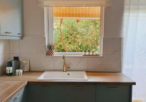 a kitchen with a sink and a window at Tashó Simply Living in Xylokastro