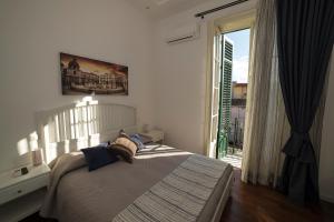 a bedroom with a bed and a large window at Ai Lattarini House in Palermo
