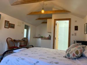 a bedroom with a bed and a kitchen at Mini Treacle Cottage in Dundry