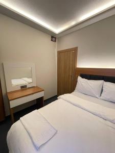 a hotel room with two beds and a desk at Hotel Bergama in Istanbul
