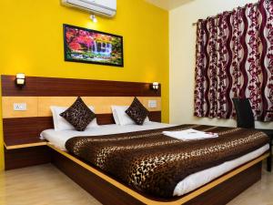 a bedroom with a large bed in a room at Hotel Matheran Gaurav Cottage in Matheran