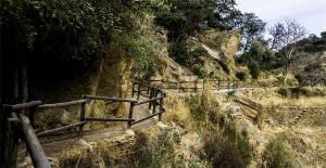 a stone path on a hill with a fence at Los Tumbaos - El Tumbao Hidromasaje entre roca natural in Laroya