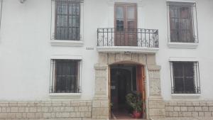 ein weißes Gebäude mit einer Tür und einem Balkon in der Unterkunft Hotel Museo Casona Ugarte Leon in Concepción