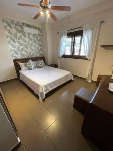 a bedroom with a bed and a ceiling fan at Villa Balmoral in Peyia +42 photos