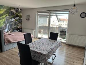 a dining room with a table and chairs and a bedroom at Studio Green in Świebodzice