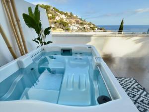 a hot tub on a balcony with a view of the ocean at Casa del Sol Jacuzzi privado y vistas al Mediterráneo en Altea Hills in Altea
