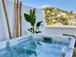 a bathtub with a window and a plant at Casa del Sol Jacuzzi privado y vistas al Mediterráneo en Altea Hills in Altea