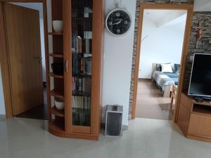 a living room with a couch and a clock on the wall at Mirni krov in Dražice