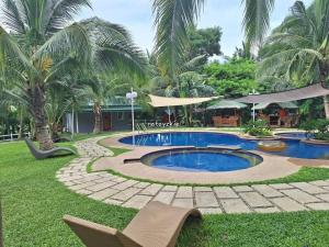 a swimming pool in a yard with chairs and trees at Starksway Resort in Calubcub Primero +4 photos