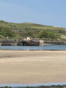 a boat sitting in the water next to a beach at 49 Strawberry Hill in Hayle