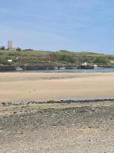 a sandy beach with a body of water at 49 Strawberry Hill in Hayle +2 photos