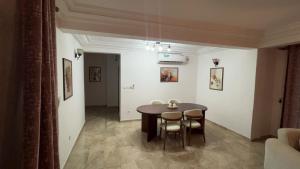 a dining room with a table and chairs in a room at Appartement cozy Bonamoussadi, WIFI & Goupe électrogène in Douala
