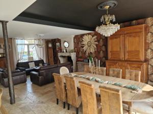a dining room with a table and a chandelier at Le Reflet de la Semoy in Les Hautes-Rivières