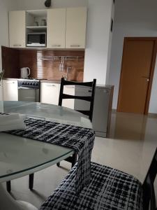 a kitchen with a glass table and a chair at Mirni krov in Dražice +8 photos