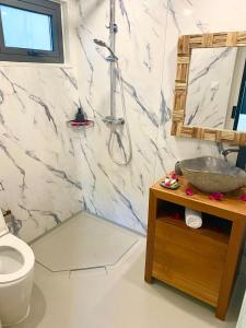 a bathroom with a sink and a toilet and a mirror at Moderne Lodge Tropical in Les Abymes +10 photos