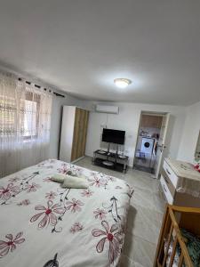 a bedroom with a bed with a floral bedspread at Vila Ansi Klean in Udënisht