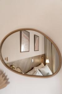 a mirror hanging on a wall above a bed at Mesogitonia House in Zekros