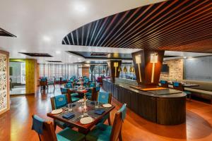 a restaurant with tables and chairs and a bar at The Classic Hotel in Imphal