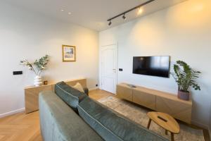 a living room with a couch and a flat screen tv at NIDO Park view in Daugavpils