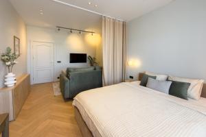 a bedroom with a large bed and a couch at NIDO Park view in Daugavpils