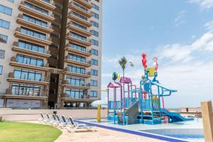 a playground in front of a apartment building at Sandy Shore Beach Apartments - Karibu Quarters in Kikambala