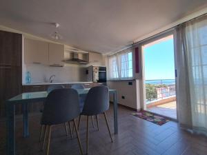 a kitchen with a table and chairs and a large window at B&B Vista Mare "Terrazzo" in Palmi