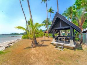 a small shack on a beach with palm trees at Beachfront! 5 Bedrooms - Malee Beach Villa E1 in Ko Lanta +22 photos