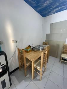 a kitchen with a table and chairs with a bowl on it at Rusde's Komodo Homestay in Pulau Komodo