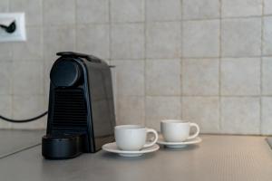 two coffee cups on a counter next to a toaster at Coastal Escape - 2 min from Perissa Beach in Perissa