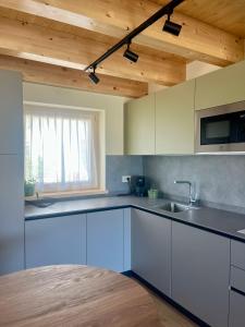 a kitchen with white cabinets and a wooden ceiling at Mirtillo in Tassullo +24 photos