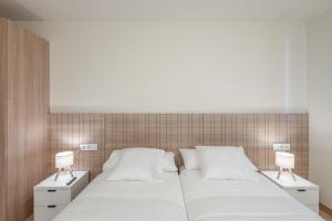 a large white bed with two nightstands and two lamps at Be1960 segon in Bagá