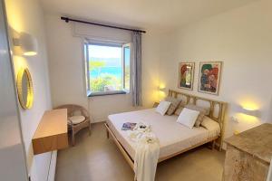 a bedroom with a large bed and a window at Residence Capobianco in Portoferraio