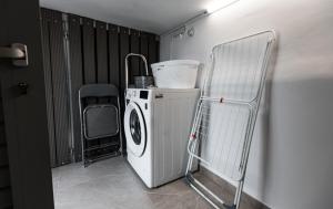 a laundry room with a washing machine and a chair at Liopetro in Sitia