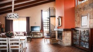 a living room with a table and a fireplace at Casa Pirinea, Maello, Avila in Maello