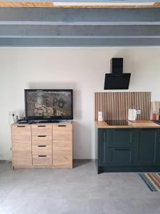 a living room with a tv on a wooden dresser at Reset w górach in Ponikwa