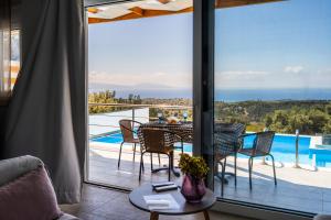 a living room with a table and chairs on a balcony at Vrachos Nature Lodges Thyme 1, Private pool in Agia Galini