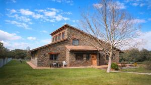 a brick house with a tree in front of it at Casa Pirinea, Maello, Avila in Maello