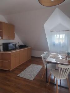 a kitchen and dining room with a table and chairs at Ostoja Jaczno in Smolniki