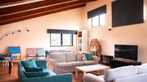 a living room with two couches and a tv at Casa Pirinea, Maello, Avila in Maello