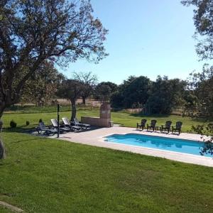 a swimming pool in a yard with chairs around it at Casa Pirinea, Maello, Avila in Maello