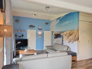 a living room with blue walls and a couch at Bungalow Nathalie in Julianadorp
