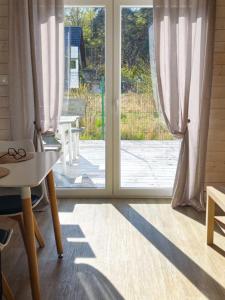 a room with a door open to a patio at TuNaChill domki nad morzem w Dziwnowie in Dziwnów