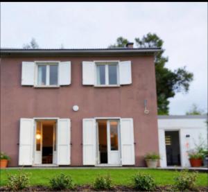 a large brick house with white shutters at Cozy spa sun set in Trois Bassins
