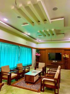 a living room with furniture and a flat screen tv at Richmount Natural Resort Pvt Ltd in Yercaud