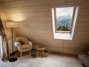 a room with a chair and a window at Willa Baciarka-widok, basen, sauna, jacuzzi in Kościelisko +70 photos