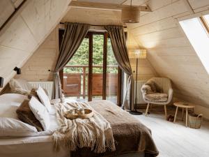 a bedroom with a large bed with a large window at Willa Baciarka-widok, basen, sauna, jacuzzi in Kościelisko